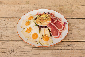Goat cheese salad with serrano ham, lettuce, pear slices