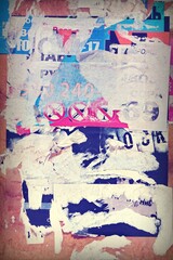 Vertical Old Wall Background With Torn Posters, Stickers and Advert.