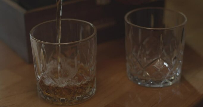 Pouring whiskey in a crystal whisky tumbler.
