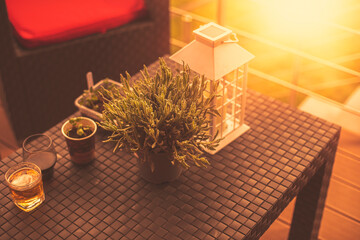 Modern house terrace with lantern, glasses and plants on the table.