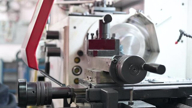Close up view of worker operating a high precision turning operation on a multi axis lathe, CNC machine tool. High quality 4k footage
