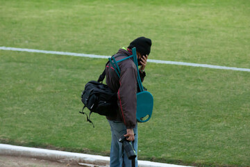 Jogo de futebol brasileiro camisa azul e listrada. Bandeirinha com bandeira listra e gandula.
