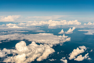 Clouds from a height of ten kilometers. Sea of clouds from the plane window. Blue sky and white clouds. The Heavenly World of White Silence