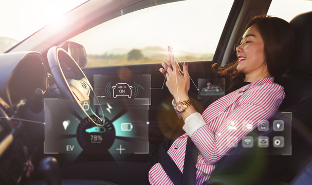 Woman using Smartphone mobile controlling car system dashboard HUD screen display system selecting option on car function interactive control concept, electric car energy saving security power charge.