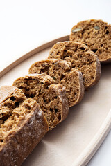 Closeup of fresh bread on the wooden plate. Minimal still life of loaf of home baked.Nutrition concept. 