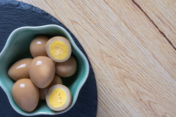 黒い石のスレートプレートに置かれた醤油と砂糖で味付けたうずらの卵