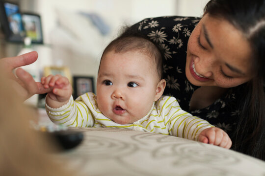 Close Up Of Parents Playing With Baby Daughter