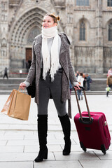 portrait of female with baggage in the historical city in scarf