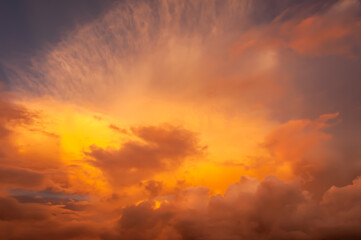 Colorful clouds formation like a wave in yellow to pink gradation tones, illuminated by a magic sunlight. Cumulonimbus and cirrus.