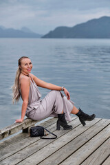 Fototapeta na wymiar Pretty woman on pier by water. Harrison Hot Springs village by Harrison lake. British Columbia. Canada 