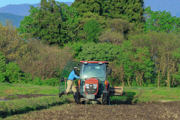 Fototapeta premium トラクターでの代掻き作業（田掻き） 農業 水田 稲 農家