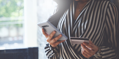 Woman enjoys using an online shopping program and checking her credit card for a payment number