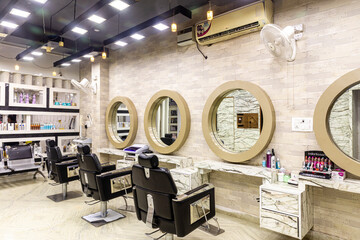 View inside of a modern salon showing mirrors and sitting arrangement. Beauty parlour interiors.