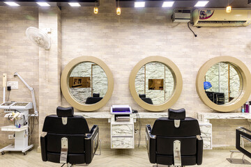 View inside of a modern salon showing mirrors and sitting arrangement. Beauty parlour interiors.