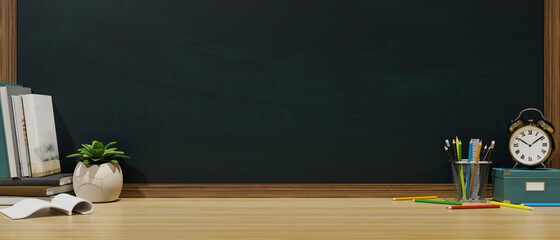 Study table with books, stationery, plant pot, alarm coco and copy space on the table with blackboard wall, 3D rendering