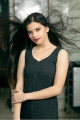 Fototapeta premium Portrait of an attractive Indian young female, fashion model for advertisement, hair flying for fashion look.