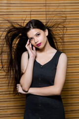 Portrait of an attractive Indian young female, fashion model for advertisement, hair flying for fashion look. © Bhaven