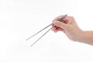 Man's hand holding stainless steel chopsticks on isolated white background
