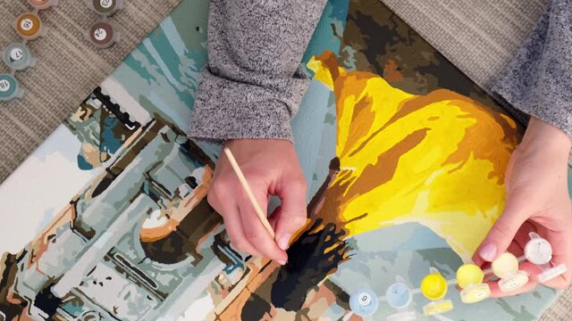 4k Female hands coloring draw canvas Picture by numbers girl Triumphal Arch Paris. Creative hobby. Painting for beginners. Leisure activity for stay home isolation, anti-stress idea. Meditation, relax