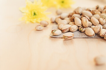 Pile of pistachios on wooden textured background. Pistachio is a healthy vegetarian protein nutritious food. Vegetarian food concept.