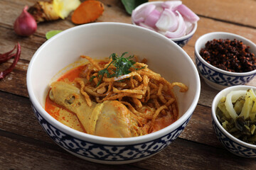 Local northern Thai food Egg noodle curry with chicken on wood background
