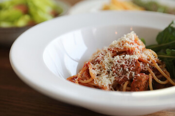 spaghetti Bolognese with italian sausage and tomato sauce with parmesan cheese and basil