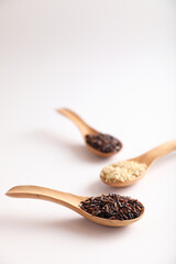 Organic raw brown rice and riceberry rice on spoon in close up
