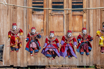 Colorful puppets in a tourist stall on the street market in Burma, Myanmar. Handmade dolls hanging...
