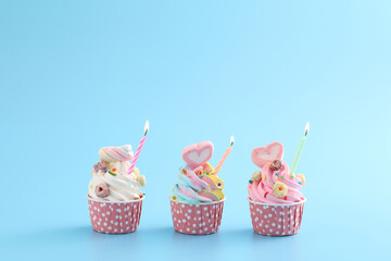 Colorful cupcakes with candle isolated in blue background