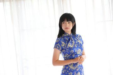 beauty woman wear blue cheongsam looking and smile in chinese new year