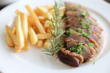 Duck magret confit with chips on wood table