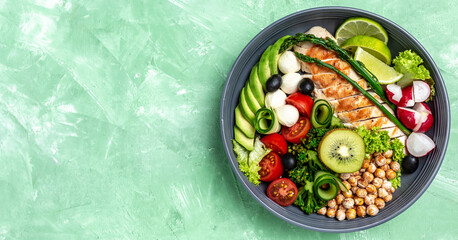 Buddha bowl dish with chicken fillet, avocado, asparagus, chickpeas, broccoli, radish, chicken, cucumber, tomatoes, olives, mozzarella. Detox and healthy superfoods concept, top view
