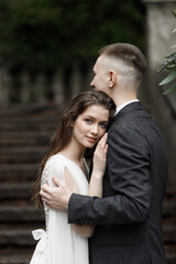 Fototapeta premium Wedding in an old villa, a happy couple holding hands. European-style wedding ceremony on the stairs.