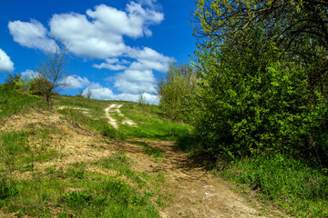Abandoned road leading to the top of the hill. A hill of clay and chalk. Spring landscape. 