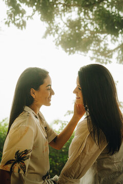 Jóvenes lesbianas de la selva peruana se miran entre si mientras una de ellas recibe una caricia en el rostro