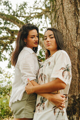 Obraz premium Retrato de pareja de lesbianas posando al lado de un árbol 