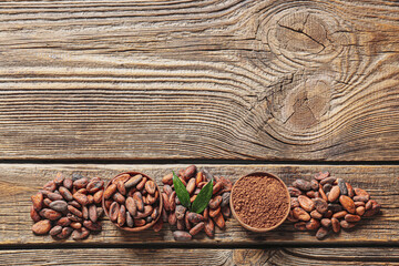 Bowls with cocoa beans and powder on wooden background