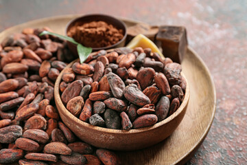 Bowl with cocoa beans on grunge background, closeup