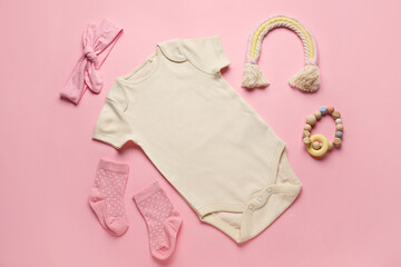 Set of baby clothes, socks and toy on color background
