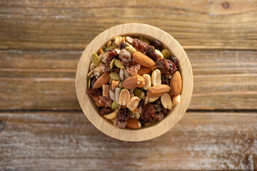 A top down view of a wood bowl of trail mix.