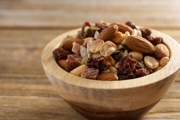 A closeup view of a wood bowl of trail mix.