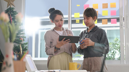 Two young designer working on startup project together in office.