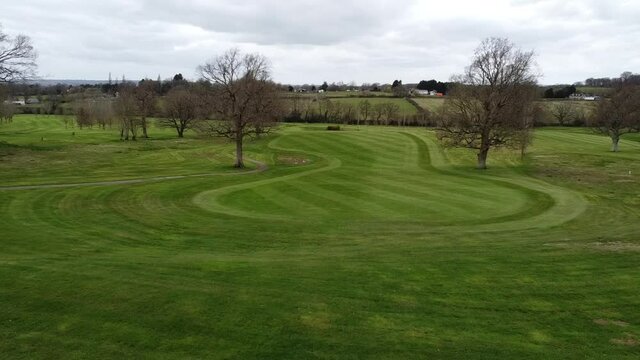 Here is a pull back drone shot of a dog and 2 men standing on the top of a hill in England