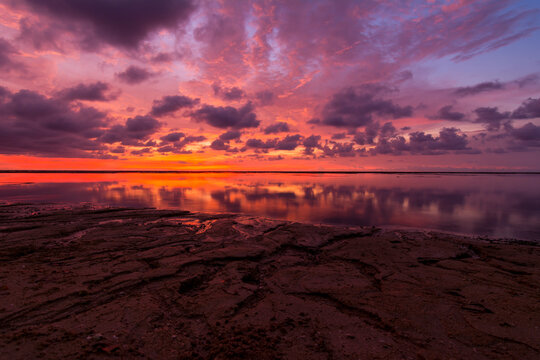 Sunset at the beach of Hermana Mayor Island in Santa Cruz, Zambales. Low tide, with exposed reef breakwater visible from afar. Facing South China Sea.