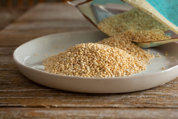 A closeup view of a pile of dried quinoa on a dish.