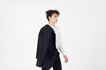 curly guy in a jacket shirt and trousers on a light background cropped view of the model