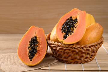 Ripe papaya fruit in a basket on wooden background, Tropical fruit