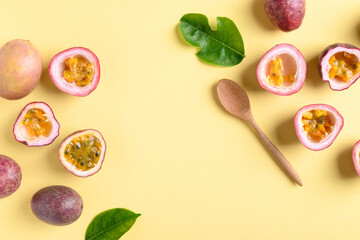 Fresh passion fruit with wooden spoon on yellow background, Flat lay, Top view