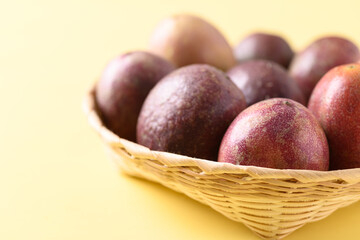 Fresh passion fruit in a bamboo basket on yellow background