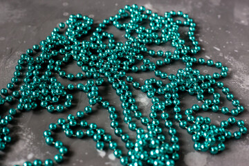 Long turquoise beads from lie on a gray surface